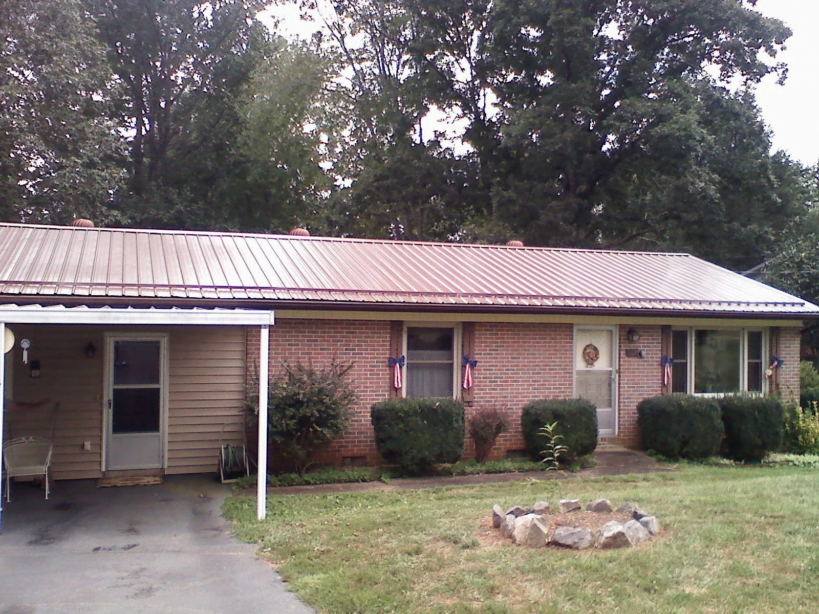 Bronze metal roof and carport on a brick ranch home — Roof Repair work by our crew in Stanton
